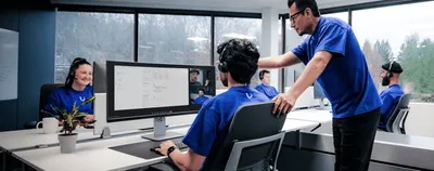 UniFi Professional Site Support 1 Jahr 24x7 EU, drei Support-Mitarbeiter in blauem Shirt mit Headsets in modernem Büro bei UniFi Professional Site Support 1 Jahr 24x7 EU, drei Support-Mitarbeiter in blauem Shirt mit Headsets in modernem Büro bei