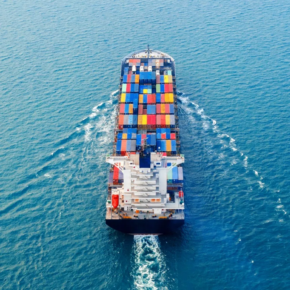 Container cargo ship in aerial view transporting colorful shipping containers across open ocean waters