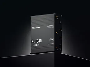 Teltonika RUTX40 4G Edge Router standing upright on reflective surface with 4G LTE badge, logo, and orange ports against