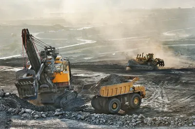 Weiße Poynting PUCK-2 MIMO LTE-Antenne (6dBi, SMA) auf Baustelle mit Bagger, Muldenkipper und Planierraupe im Tagebau.