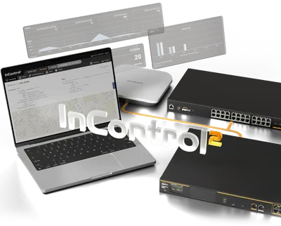 Ноутбук с панелью управления сетью InControl 2 рядом с точкой доступа Pepwave Balance 580X и двумя маршрутизаторами Peplink