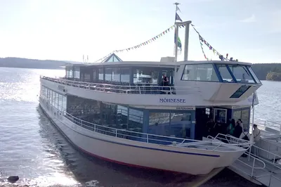 Poynting A-OMNI-0914-V1-01 5G/LTE-Marineantenne weiß auf dem Passagierschiff MÖHNESEE mit Glasgeländern und bunten Wimpeln