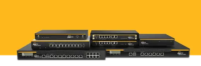 Antena Wi-Fi Dual-Band Omni negra junto a routers y switches Peplink Balance en superficie verde sobre fondo amarillo. Antena Wi-Fi Dual-Band Omni negra junto a routers y switches Peplink Balance en superficie verde sobre fondo amarillo.