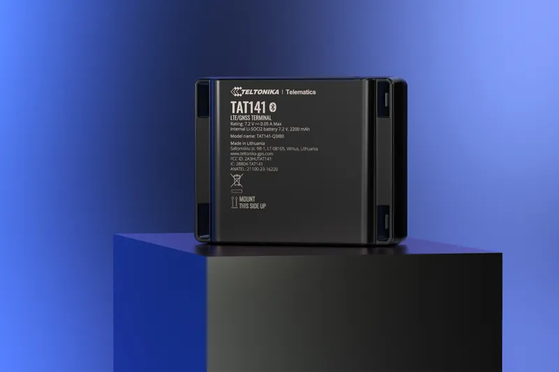 Трекер TELTONIKA TAT141 с 4G LTE Cat M1 на тёмной подставке на фоне синего градиента с техническими характеристиками на