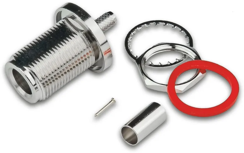 Chrome coaxial wall socket with disassembled mounting hardware—threaded barrel, locking ring, hexagonal nut, red gasket,