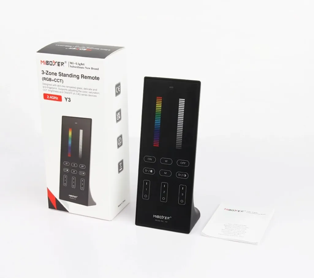 MiBoxer Y3-B 2.4GHz RGB-WW 3-zone vertical remote with rainbow touch strip on white surface next to packaging and manual. MiBoxer Y3-B 2.4GHz RGB-WW 3-zone vertical remote with rainbow touch strip on white surface next to packaging and manual.