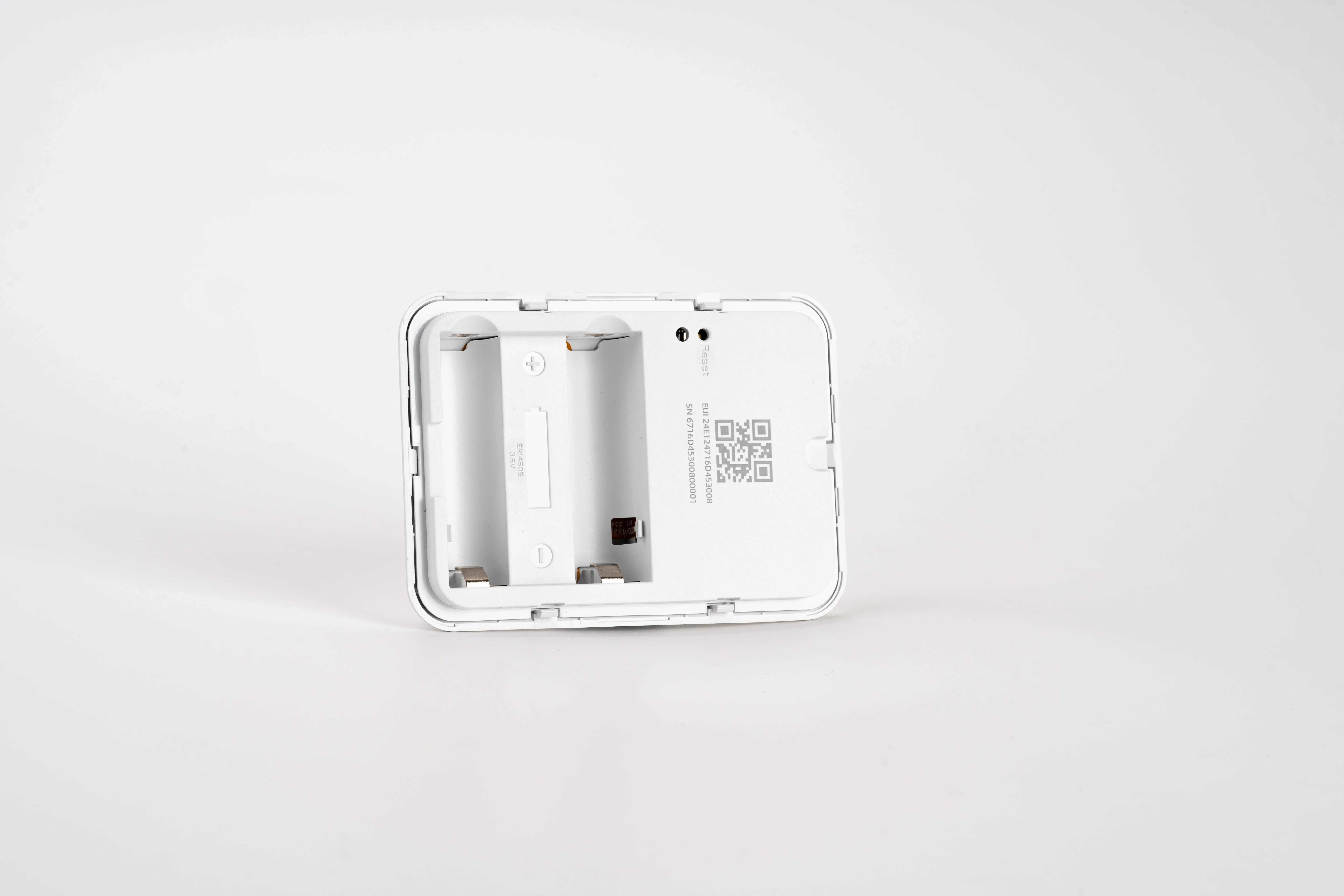 Sensor IoT Milesight VS350-860M con compartimento de batería ER14505 visible, orificios de reinicio y código QR en carcasa