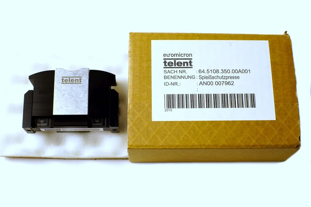 NetPeppers LWL Glasfaser splice protector press with telent branding next to its cardboard packaging box on a workbench.