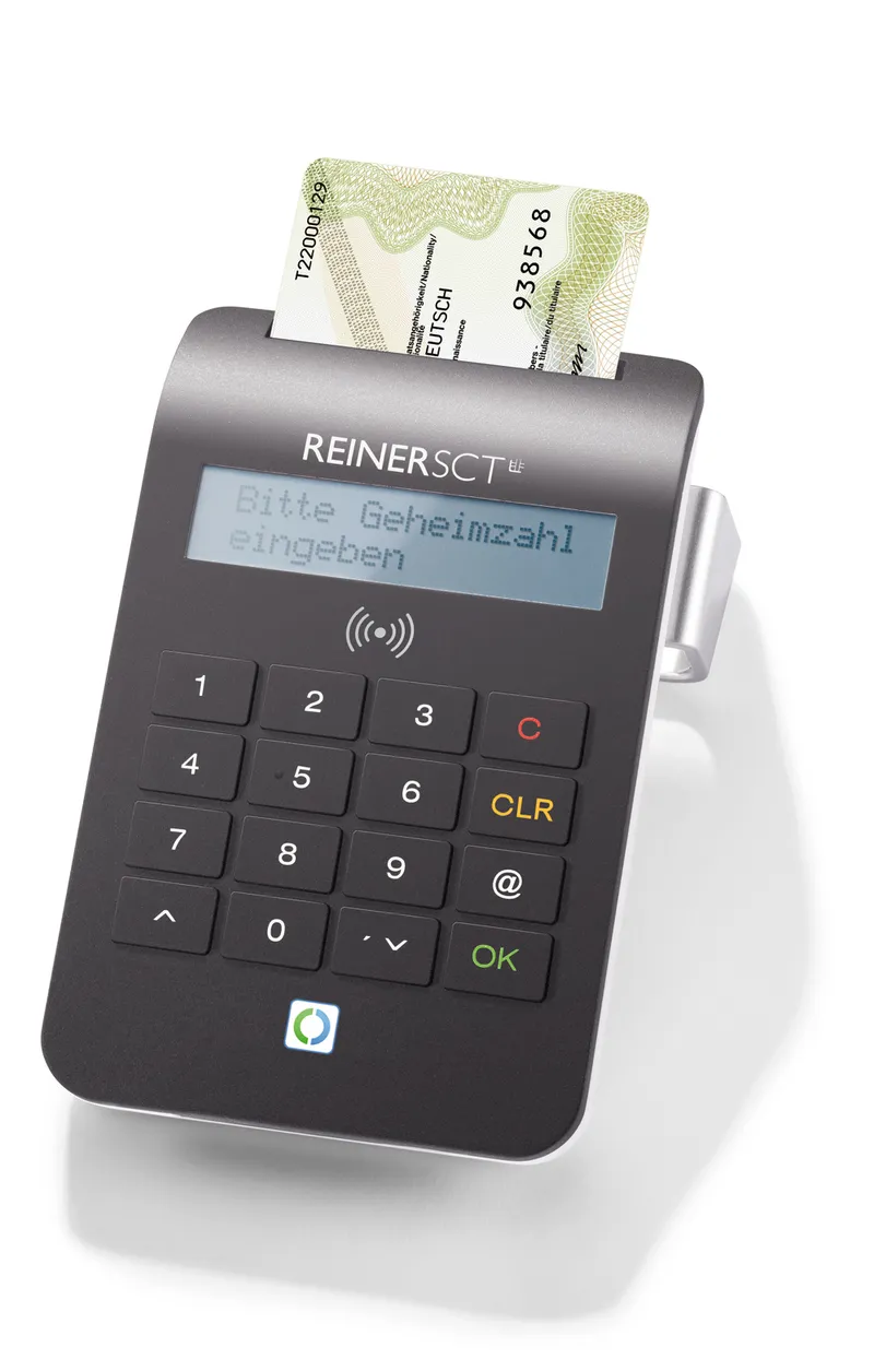 REINER SCT cyberJack RFID komfort mit teilweise eingestecktem deutschen Personalausweis auf weißer Fläche, Display zeigt