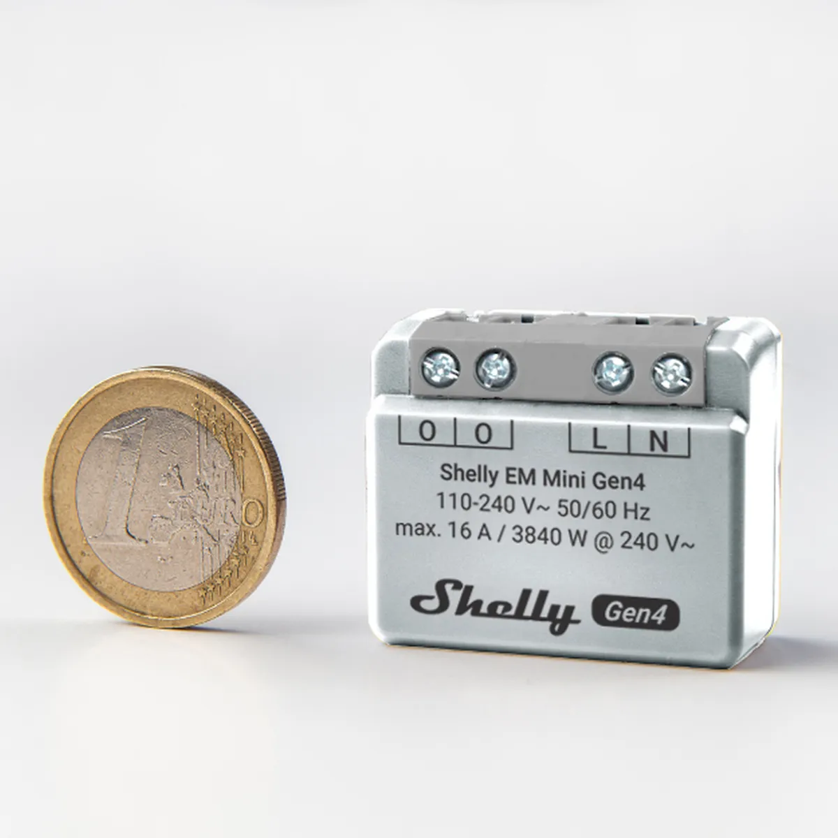 Shelly EM Mini Gen4 smart relay with grey terminal block and 1 Euro coin for size comparison showing WLAN, Matter, and
