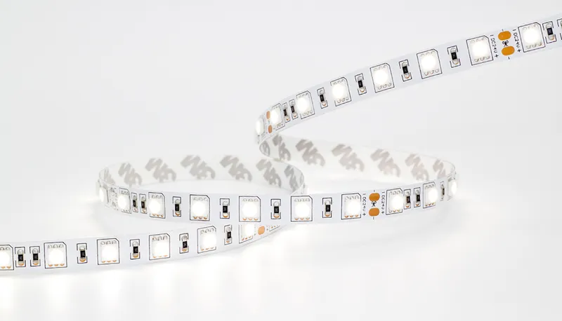 Striscia LED flessibile Synergy 21 5050 60 LED/m 72W 12V IP20 avvolta su sfondo bianco con chip quadrati e contatti in rame.