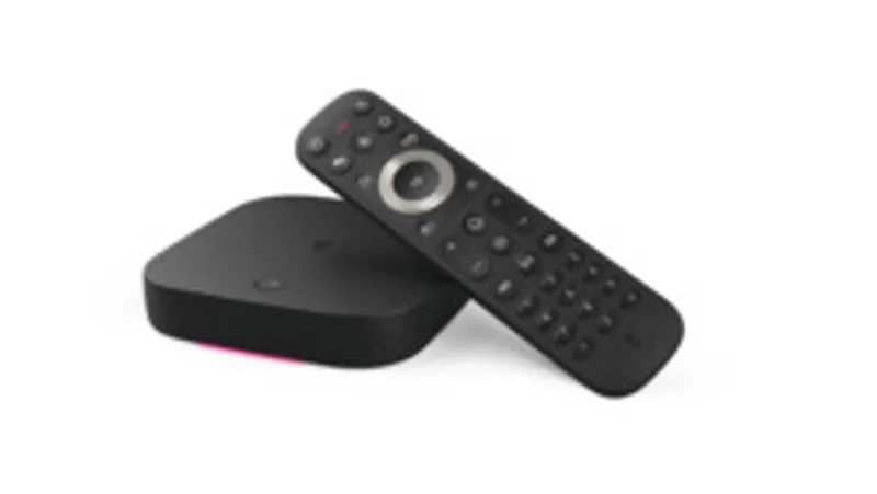 Boîtier multimédia Telekom MagentaTV One (2ᵉ Gén) barrièrefrei avec télécommande noire posée sur surface blanche, design