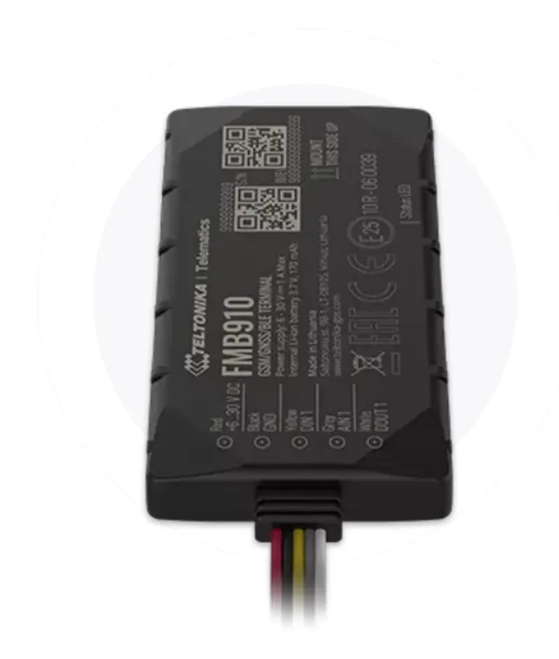 Черный прямоугольный GPS-трекер Teltonika FMB910 с надписями и проводами на разъемах, установленный на транспортном средстве.
