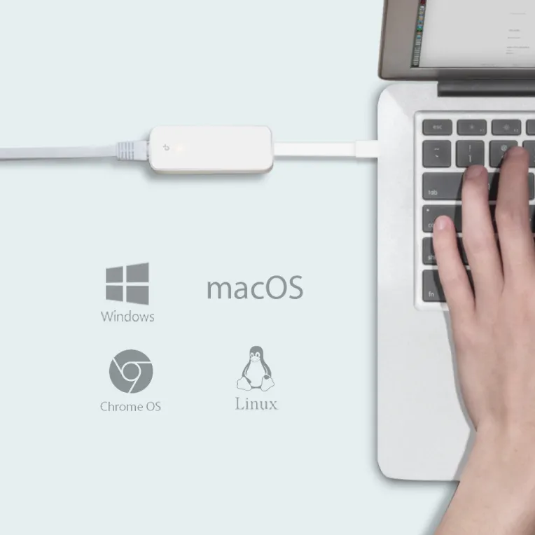 Weißer USB-C-auf-Gigabit-Ethernet-Adapter mit LED an silbernem Laptop angeschlossen während Nutzer tippt unterstützt