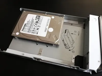 Ubiquiti UniFi Dream Machine Pro mit halb eingesetztem Toshiba 3,5-Zoll-Festplattenlaufwerk in silberner Einbaubucht mit Ubiquiti UniFi Dream Machine Pro mit halb eingesetztem Toshiba 3,5-Zoll-Festplattenlaufwerk in silberner Einbaubucht mit